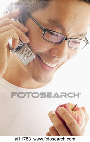 Man holding apple and using mobile phone View Large Photo Image Stock Image - Man holding apple and using mobile phone. Fotosearch