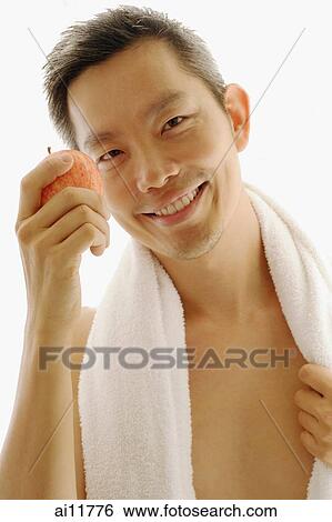 Man holding apple, looking at camera View Large Photo Image Stock Photograph - Man holding apple, looking at camera. Fotosearch
