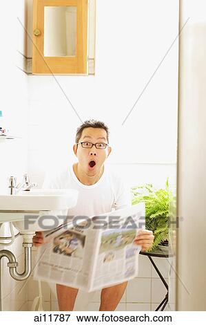 Man on toilet, holding newspaper, mouth open View Large Photo Image Stock Photo - Man on toilet, holding newspaper, mouth open. Fotosearch