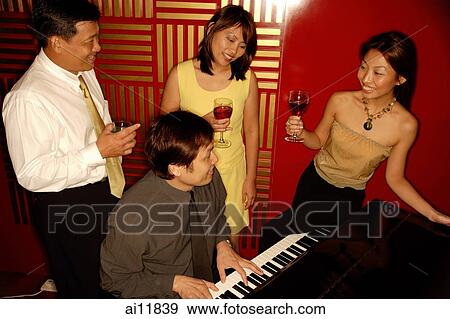 Man playing the piano, people standing around him View Large Photo Image Stock Photo - Man playing the piano, people standing around him. Fotosearch