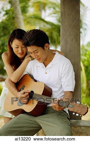 Man playing with guitar, woman leaning on his shoulder View Large Photo Image Stock Image - Man playing with guitar, woman leaning on his shoulder. Fotosearch