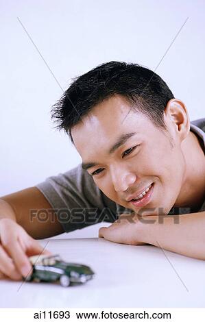Man playing with model toy car View Large Photo Image Stock Image - Man playing with model toy car. Fotosearch