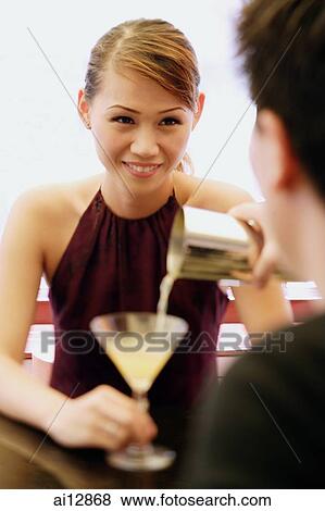Man pouring drink for woman View Large Photo Image Stock Photo - Man pouring drink for woman. Fotosearch