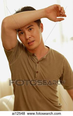 Man raising arm, looking at camera View Large Photo Image Stock Photo - Man raising arm, looking at camera. Fotosearch