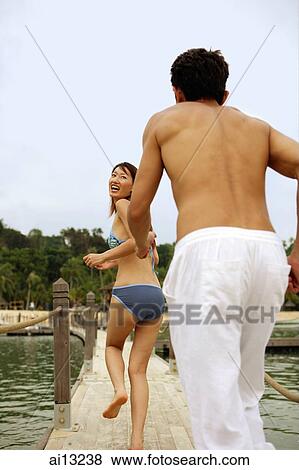 Stock Photo - Man running after woman, rear view. Fotosearch