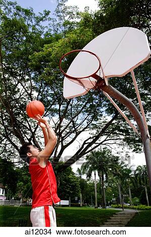 Man shooting basketball through a hoop View Large Photo Image Picture - Man shooting basketball through a hoop. Fotosearch