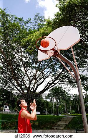 Man shooting basketball through a hoop View Large Photo Image Stock Photography - Man shooting basketball through a hoop. Fotosearch