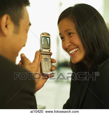 Man showing mobile phone to woman View Large Photo Image Stock Image - Man showing mobile phone to woman. Fotosearch