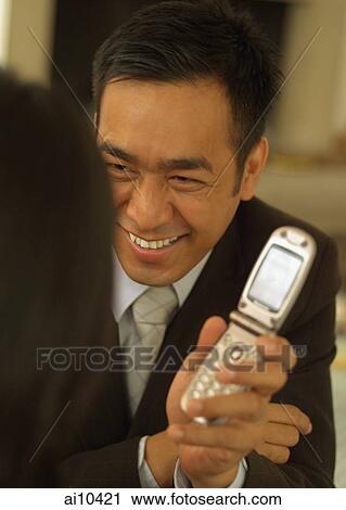Man showing mobile phone to woman View Large Photo Image Stock Image - Man showing mobile phone to woman. Fotosearch