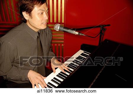 Stock Photograph - Man singing and playing the piano. Fotosearch