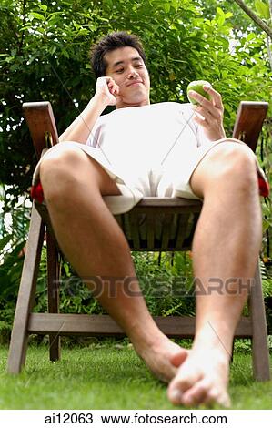 Man sitting on chair, outdoors. View Large Photo Image Stock Image - Man sitting on chair, outdoors.. Fotosearch