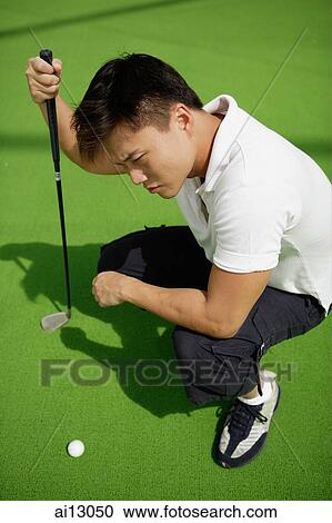 Man squatting down, looking at golf ball View Large Photo Image Stock Image - Man squatting down, looking at golf ball. Fotosearch