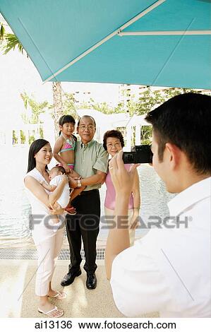 Stock Photograph - Man taking picture of his family. Fotosearch