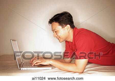 Man using laptop, profile View Large Photo Image Picture - Man using laptop, profile. Fotosearch
