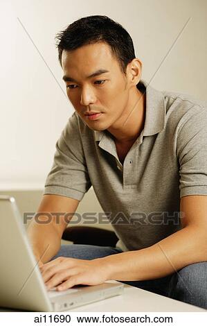 Stock Image - Man using laptop. Fotosearch
