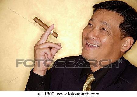 Stock Image - Man with cigar looking away, smiling. Fotosearch