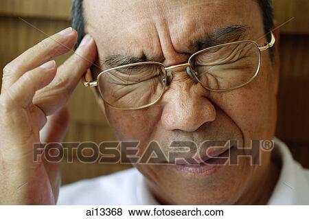 Stock Photo - Man with hand on head, eyes closed. Fotosearch