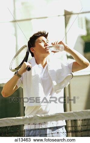 Man with tennis racket, drinking from water bottle View Large Photo Image Stock Image - Man with tennis racket, drinking from water bottle. Fotosearch