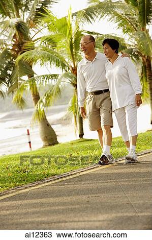 Mature couple walking in park View Large Photo Image Stock Image - Mature couple walking in park. Fotosearch