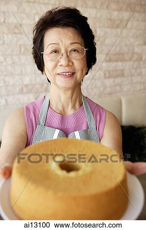 Mature lady holding out cake View Large Photo Image Stock Image - Mature lady holding out cake. Fotosearch