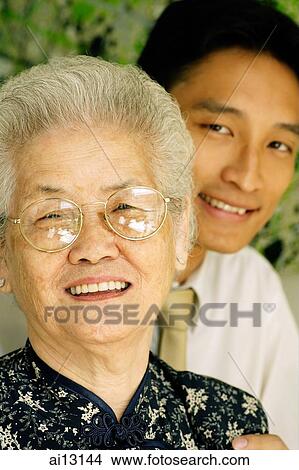 Mature woman looking at camera, man behind her View Large Photo Image Picture - Mature woman looking at camera, man behind her. Fotosearch
