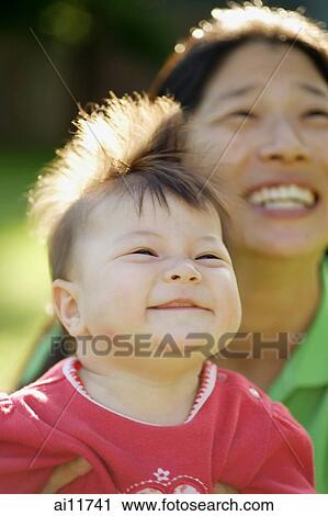 Mother and baby girl looking up, smiling View Large Photo Image Stock Image - Mother and baby girl looking up, smiling. Fotosearch