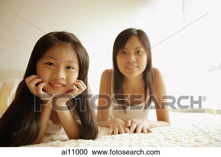 Mother and daughter in bedroom, looking at camera View Large Photo Image Stock Image - Mother and daughter in bedroom, looking at camera. Fotosearch