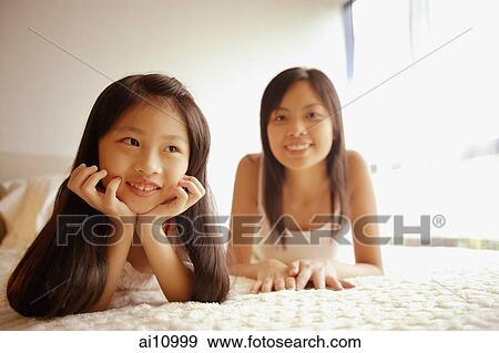Stock Photo - Mother and daughter, looking on front, looking at camera. Fotosearch
