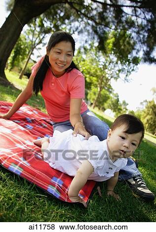 Mother and daughter on picnic blanket in park View Large Photo Image Stock Photo - Mother and daughter on picnic blanket in park. Fotosearch