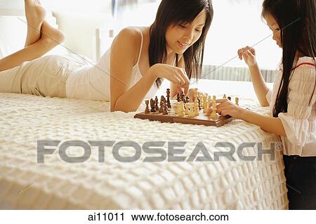 Mother and daughter playing chess in bedroom View Large Photo Image Stock Image - Mother and daughter playing chess in bedroom. Fotosearch