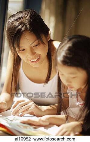 Mother and daughter, side by side, looking at magazine View Large Photo Image Stock Image - Mother and daughter, side by side, looking at magazine. Fotosearch