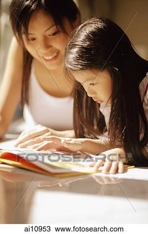 Mother and daughter, side by side, looking at magazine View Large Photo Image Stock Image - Mother and daughter, side by side, looking at magazine. Fotosearch