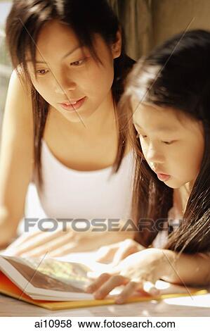 Mother and daughter, side by side, looking at magazine View Large Photo Image Stock Photo - Mother and daughter, side by side, looking at magazine. Fotosearch