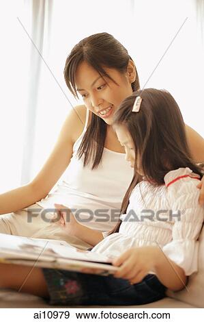 Mother and daughter, sitting side by side, looking at book View Large Photo Image Stock Photo - Mother and daughter, sitting side by side, looking at book. Fotosearch
