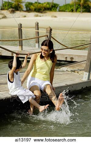 Mother and son, sitting with legs in water View Large Photo Image Stock Photo - Mother and son, sitting with legs in water. Fotosearch