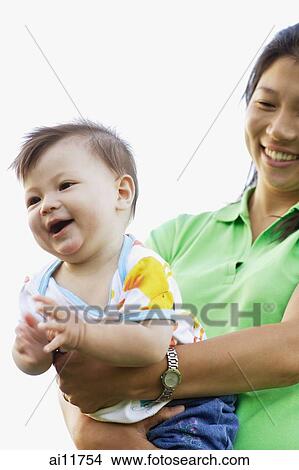 Mother carrying baby girl View Large Photo Image Picture - Mother carrying baby girl. Fotosearch