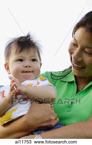 Mother carrying baby girl, portrait View Large Photo Image Stock Image - Mother carrying baby girl, portrait. Fotosearch