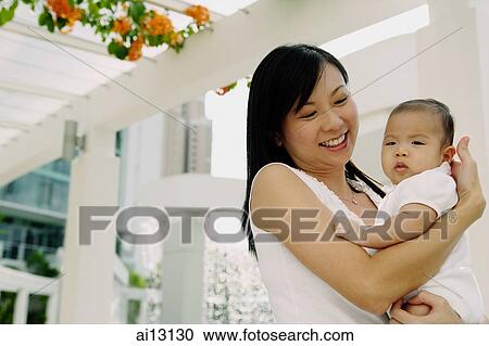 Stock Image - Mother carrying baby girl. Fotosearch