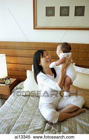 Stock Photography - Mother carrying baby girl. Fotosearch