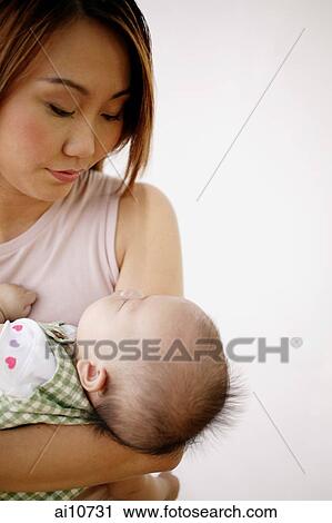 Stock Image - Mother carrying baby. Fotosearch