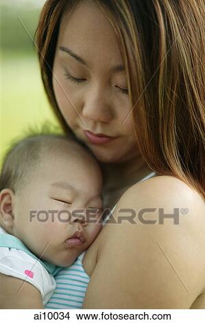 Picture - Mother carrying sleeping baby. Fotosearch