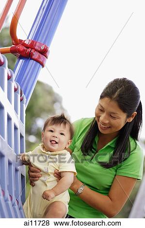 Mother in playground with baby girl View Large Photo Image Stock Photo - Mother in playground with baby girl. Fotosearch