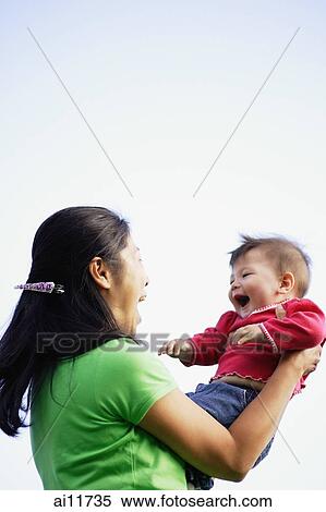 Mother lifting baby girl, face to face View Large Photo Image Stock Photography - Mother lifting baby girl, face to face. Fotosearch