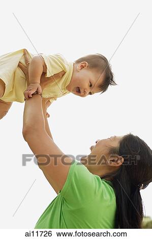 Stock Photograph - Mother lifting baby girl. Fotosearch