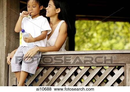 Stock Photo - Mother with son, son sitting on ledge.. Fotosearch