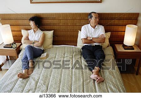 Older couple lying apart on bed, arms crossed View Large Photo Image Stock Photograph - Older couple lying apart on bed, arms crossed. Fotosearch
