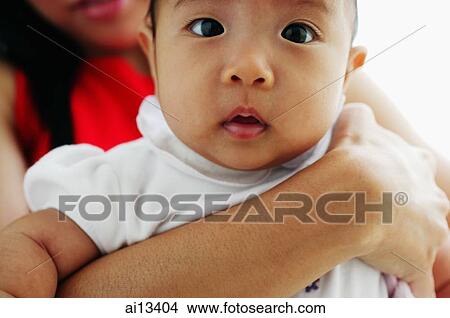Portrait of a baby girl, mother carrying her View Large Photo Image Picture - Portrait of a baby girl, mother carrying her. Fotosearch