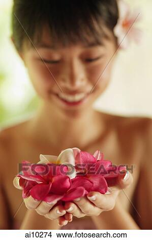Portrait of a young woman, holding flowers View Large Photo Image Picture - Portrait of a young woman, holding flowers. Fotosearch