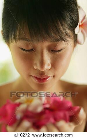 Portrait of a young woman, holding flowers View Large Photo Image Stock Image - Portrait of a young woman, holding flowers. Fotosearch