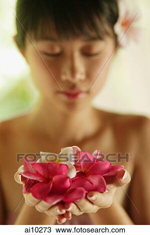 Portrait of a young woman, holding flowers View Large Photo Image Stock Image - Portrait of a young woman, holding flowers. Fotosearch